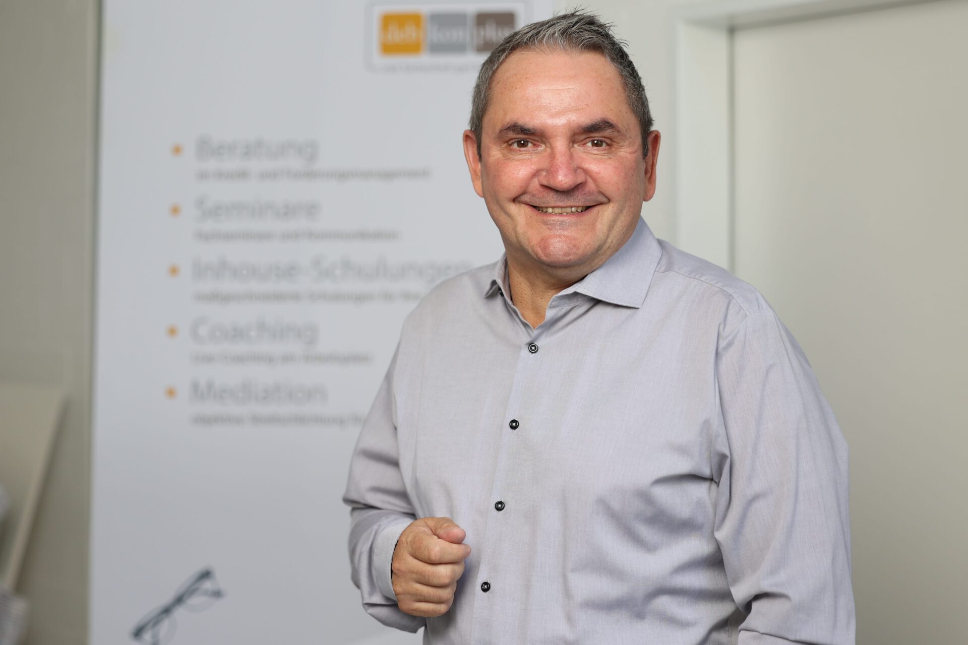 Lächelnder Mann vor Beratungsposter
