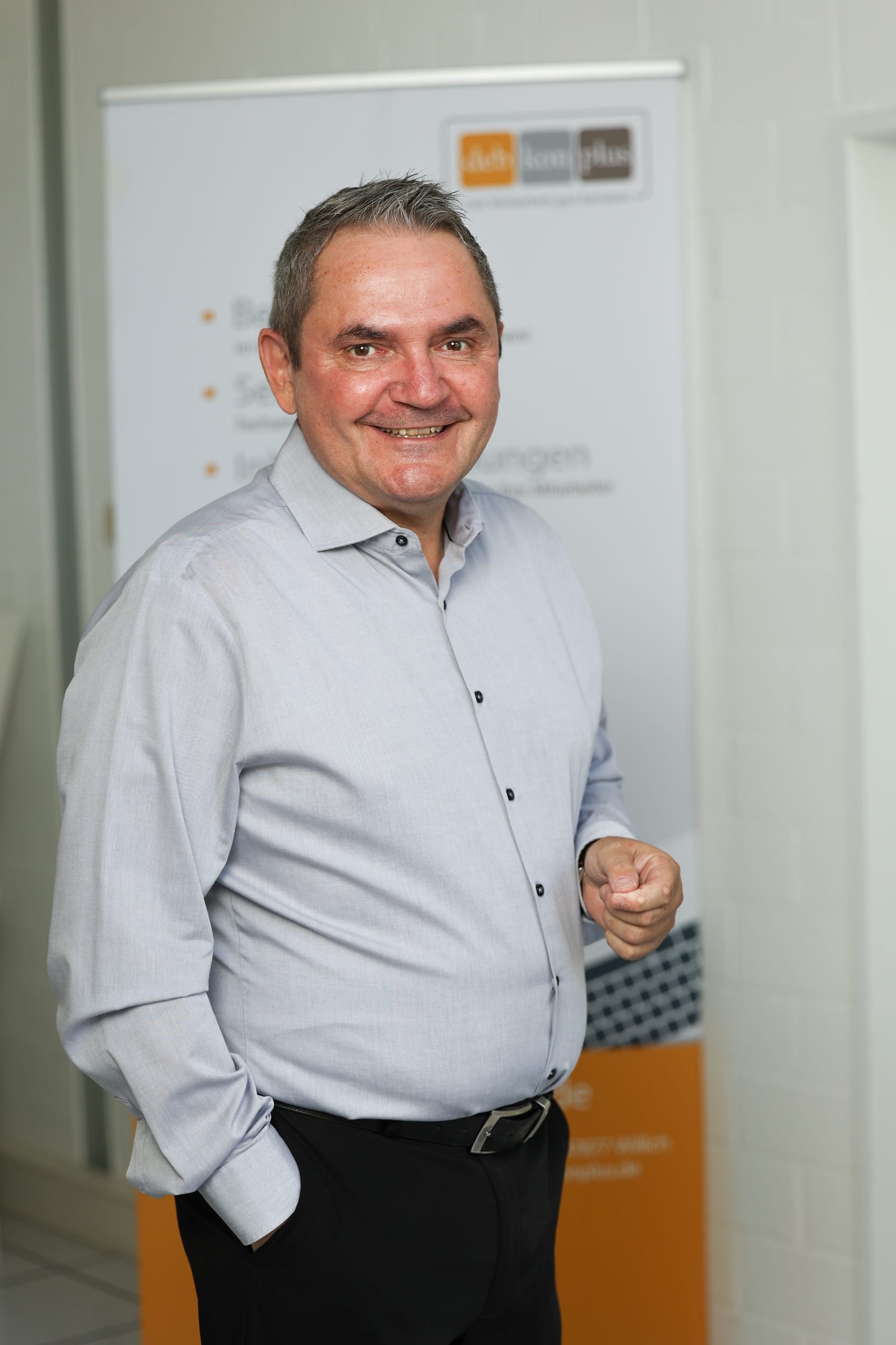 Mann lächelt vor einem Roll-Up-Banner