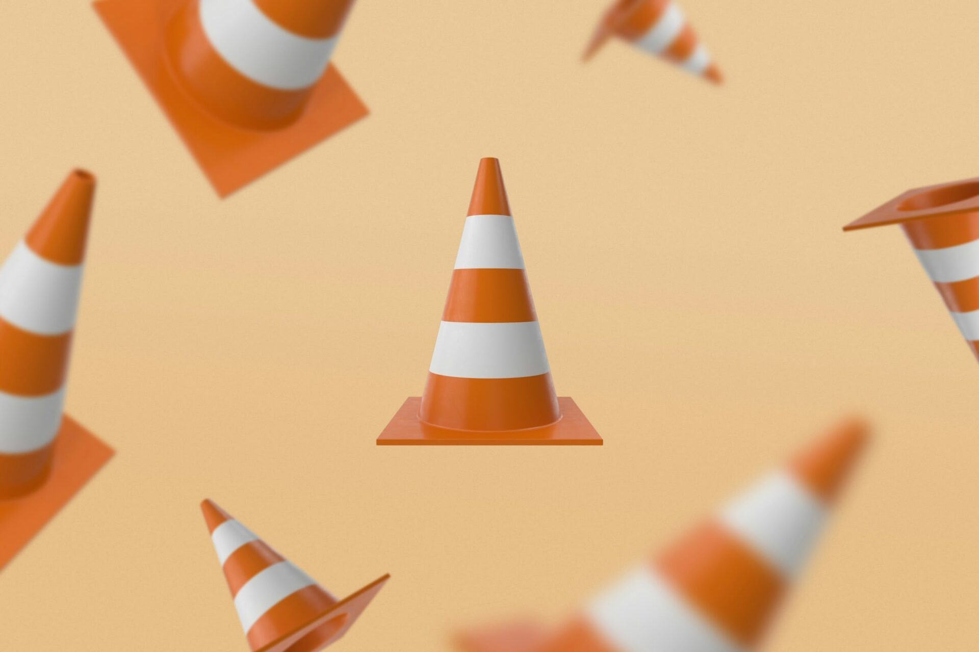 Schwebende Verkehrsleitkegel auf orangem Hintergrund.