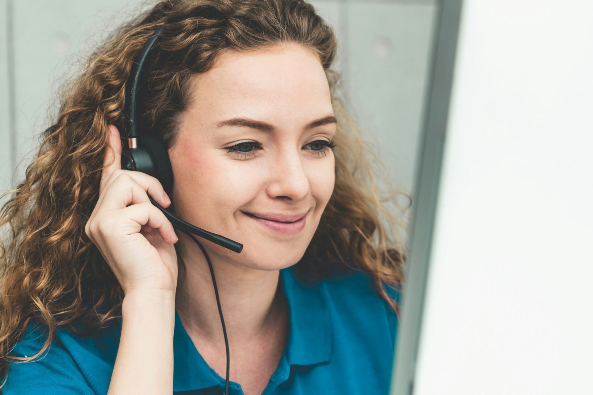 Frau mit Headset lächelt am Computer