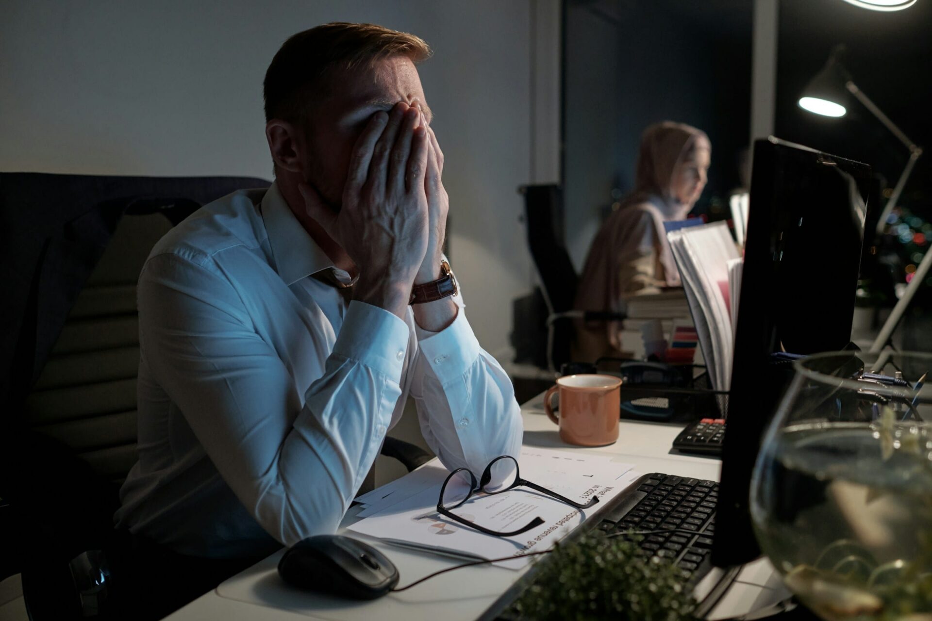 Gestresster Mann im Büro bei Nacht
