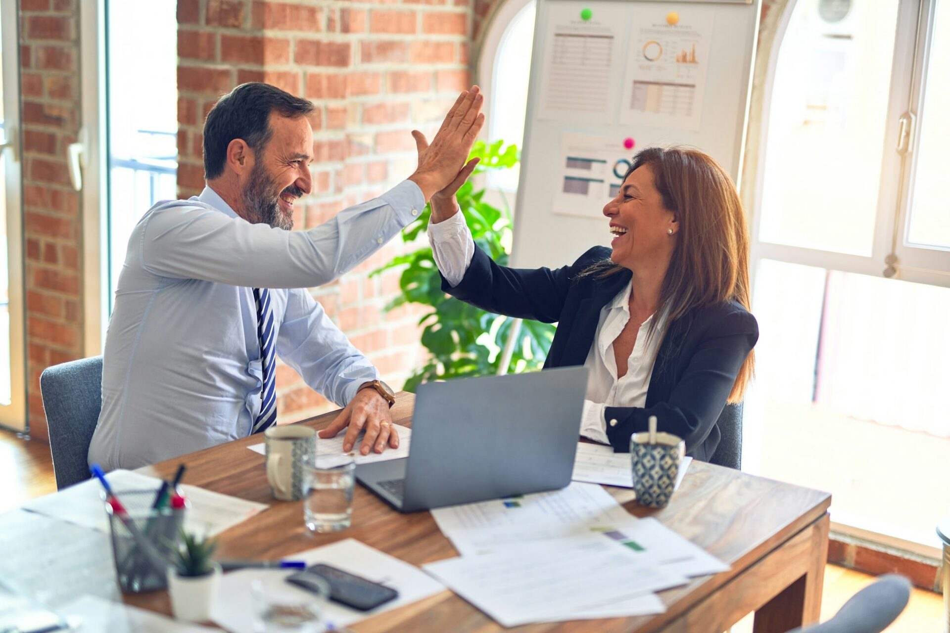 Zwei Personen geben sich High-Five im Büro.