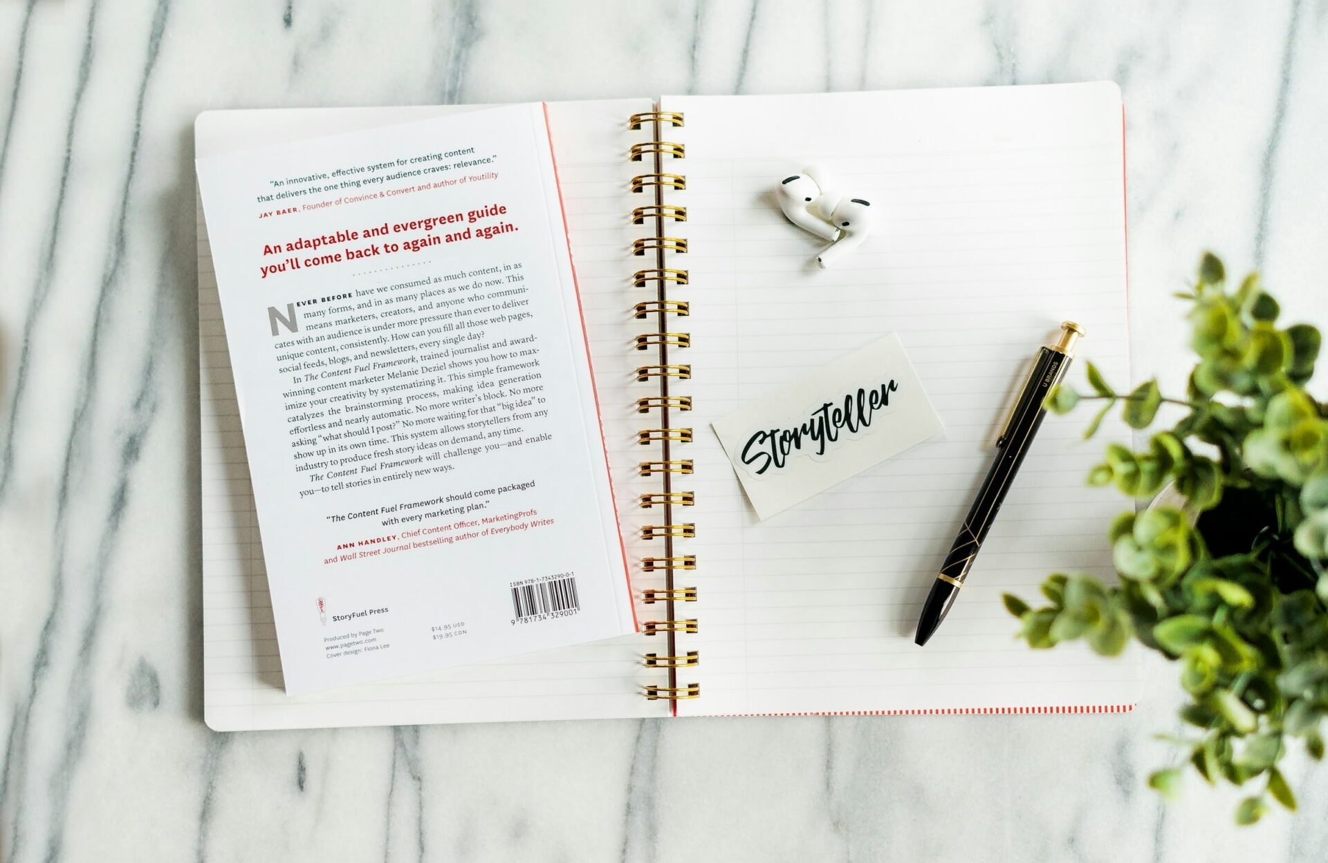 Buch, Notizbuch, Stift und Ohrhörer auf Tisch